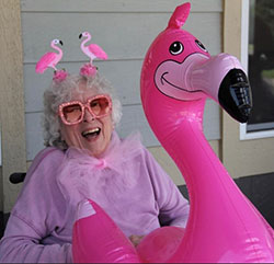 resident wearing all pink and holding an inflatable flamingo